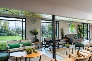 达夫纳Erettz Dafna Travel Hotel的客厅设有桌椅和窗户。