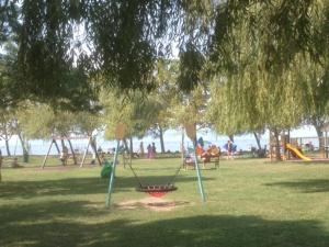 a park with a swing set in the grass at Kajüt Apartman in Balatonfenyves +5 photos