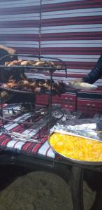 a table with several trays of food on it at Bronze Mountains Camp Wadi Rum in Wadi Rum