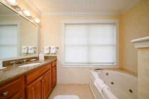 a bathroom with a tub and a sink and a mirror at Stoweflake Mountain Resort & Spa in Stowe