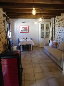 ein Wohnzimmer mit Tisch und Couch in der Unterkunft La Casita de Teléfonos in Gargantilla del Lozoya y Pinilla de Buitrago