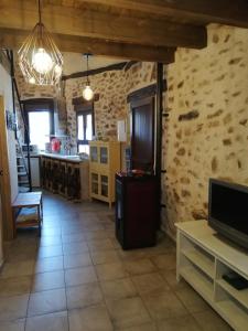 a living room with a kitchen and a tv at La Casita de Teléfonos in Gargantilla del Lozoya