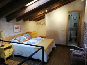 ein Schlafzimmer mit einem Bett und ein Badezimmer in der Unterkunft La Casita de Teléfonos in Gargantilla del Lozoya y Pinilla de Buitrago