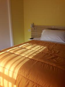 un letto in una camera da letto con copriletto dorato di B&B A Un Passo Da a Casale sul Sile