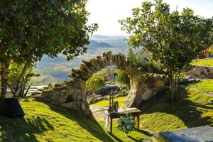 a stone archway on a hill with a view at Pousada Pedra Grande in Serra de São Bento