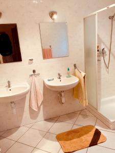 a white bathroom with a sink and a shower at Dom CROCUS z ogrodem w Parku Krajobrazowym in Brenna