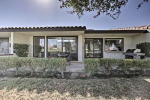 a house with windows and a patio with a grill at Rancho Las Palmas Resort Condo Golf, Swim and Play! in Rancho Mirage