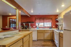 uma cozinha com paredes cor de laranja e armários de madeira em Peaceful Creekside em Orick