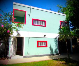 un edificio blanco con ventanas rojas y una puerta en Departamento Encantador monoambiente Domaine Laborde I en Mendoza