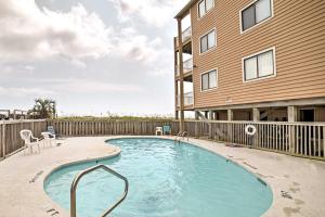 a swimming pool in front of a building at Oceanfront Carolina Beach Condo with Pool and Views! in Carolina Beach