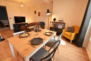 a dining room with a table and chairs and a living room at LA LOGE DU MONTCEL - T2 -1er étage in Auvers-sur-Oise