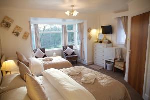 a bedroom with two beds and a dresser and a window at Villa Marina in Scarborough