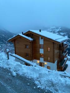 a large building with snow on the ground at Le Preyet in Veysonnaz