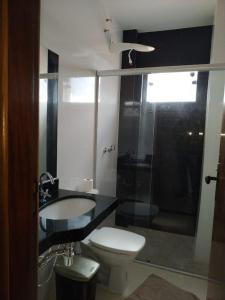 a bathroom with a toilet and a sink and a shower at Hotel Kanaan in Pimenta Bueno