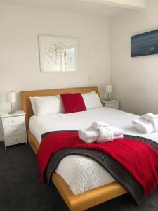 1 dormitorio con 2 camas y toallas rojas y blancas en Casa Vista Apartment by Amazing Accom, en Queenstown