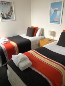 a room with three beds in a room at Casa Vista Apartment by Amazing Accom in Queenstown