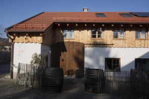 Uma casa com um monte de barris à frente. em Appartement - Ferienwohnung - FeWo Heuboden em Emmering