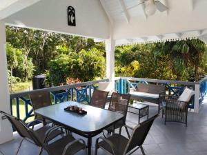 a patio with a table and chairs on a balcony at C & A Seashell Villa in Bon Accord Village