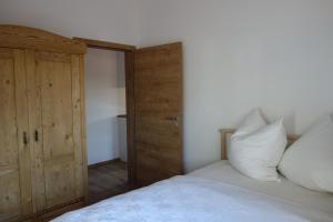 1 dormitorio con 1 cama y puerta de madera en Appartement - Ferienwohnung - FeWo Heuboden en Emmering