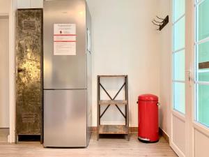 a refrigerator in a room with a red trash can at Maison de campagne Chez Trabou et Loulou 20 min de La Rochelle in Aigrefeuille-dʼAunis