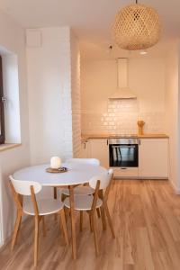 uma cozinha e sala de jantar com uma mesa branca e cadeiras em Eco apartament Nałęczów em Nałęczów