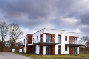 a white building with a balcony on top of it at Eco apartament Nałęczów in Nałęczów