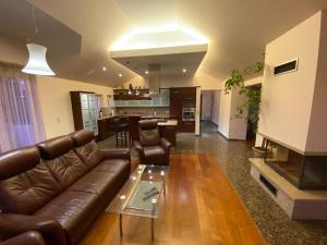 a living room with a leather couch and a table at Apartment Spirit z sauną in Sopot