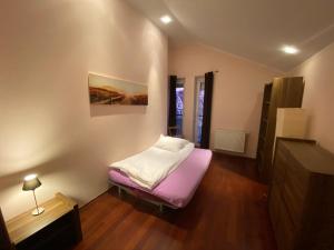 ソポトにあるApartment Spirit z saunąの紫色のマットレス付きのベッドが備わる小さな客室です。