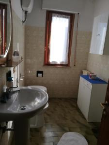baño con lavabo y aseo y ventana en Pratomagno Apartment, en Cetica