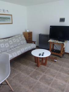 Una sala de estar con un sofá y una mesa de café. en Don Alfonso Departamento, en San Carlos de Bariloche