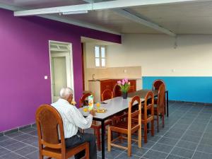 un hombre sentado en una mesa en un comedor en Casa Celeste en Ponta do Sol