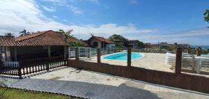 a house with a fence and a swimming pool at Hotel Nils in Itapoa