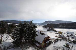 una casa cubierta de nieve con un río y montañas en Haus Verdi, en Sankt Andrä im Lungau