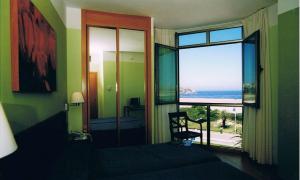 a bedroom with a window with a view of the ocean at Hotel la Concha de Suances in Suances