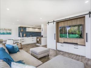 Una sala de estar con un sofá y un televisor. en Kirra Waves, en Gold Coast