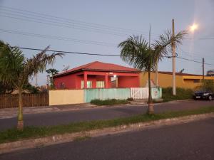 una casa roja al lado de una calle en Casa Pestana - Ilha Comprida en Ilha Comprida