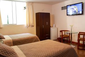 a hotel room with two beds and a flat screen tv at Hotel Ivansino Inn in Chimbote +53 photos