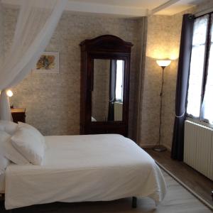 1 dormitorio con cama blanca y ventana en French Holiday Accommodation, en Bort-les-Orgues