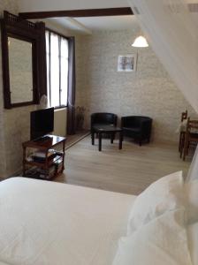 1 dormitorio con 1 cama, mesa y sillas en French Holiday Accommodation, en Bort-les-Orgues