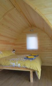 a bed in a wooden room with a window at Archers Meadow Shropshire in Ellesmere