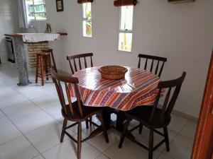 a dining room table with chairs and a bowl on it at Canto dos Pássaros Apartamentos in Florianópolis