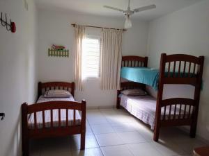 a bedroom with two bunk beds and a window at Canto dos Pássaros Apartamentos in Florianópolis