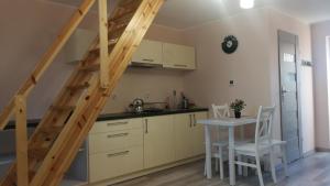 a kitchen with a table and a staircase in a room at Nad Strumykiem 2 in Duszniki Zdrój