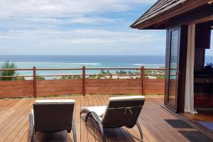 two chairs on a deck with a view of the ocean at Villa Tea Tea in Papetoai