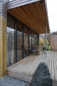 a house with a wooden deck with glass windows at Design Ferienwohnung nienrausch Apartment 2 in Timmendorfer Strand