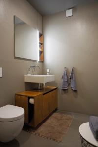 a bathroom with a sink and a toilet and a mirror at Design Ferienwohnung nienrausch Apartment 2 in Timmendorfer Strand