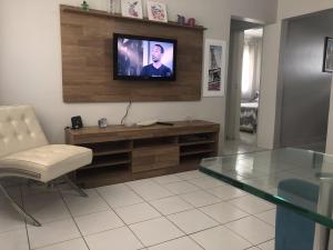 sala de estar con TV, mesa y silla en Apt. Completo em Recife, Boa Viagem - 2 qts - p/ 5 pessoas - 200m da praia, en Recife