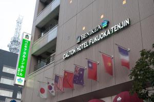 a building with flags on the side of it at Benikea Calton Hotel Fukuoka Tenjin in Fukuoka