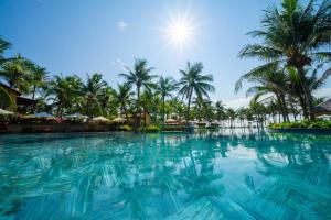 a swimming pool at a resort with palm trees at Pandanus Resort in Mui Ne