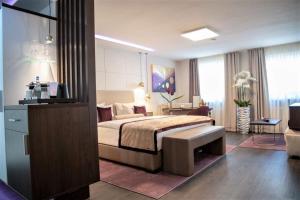 une chambre d'hôtel avec un lit et une télévision dans l'établissement Hotel Merkur - Superior, à Baden-Baden